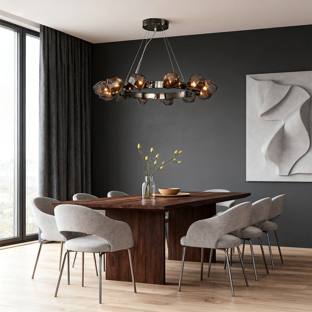 Contemporary black round chandelier suspended above a rustic wood dining table with dark walls and panoramic windows.