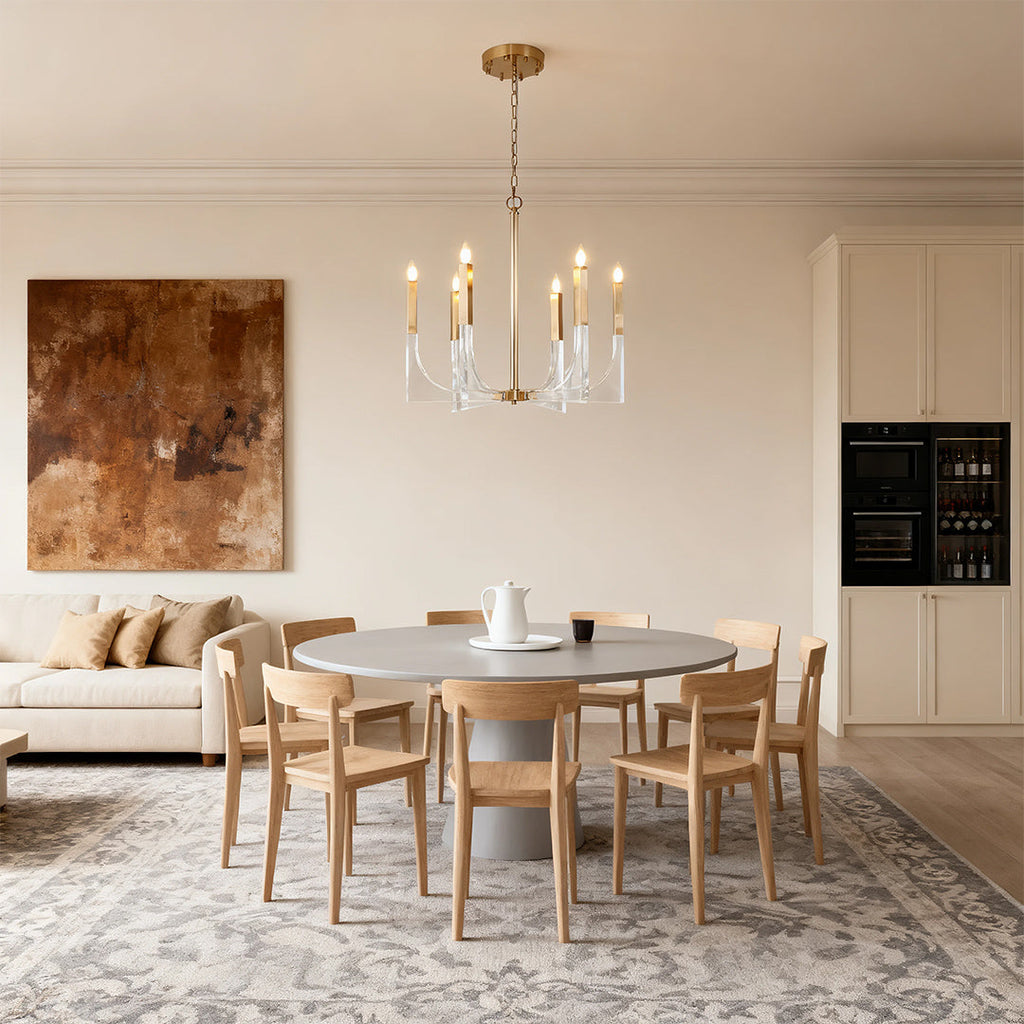 Acrylic chandeliers providing elegant ambient light above a round wooden dining table in a contemporary minimalist kitchen/dining area.