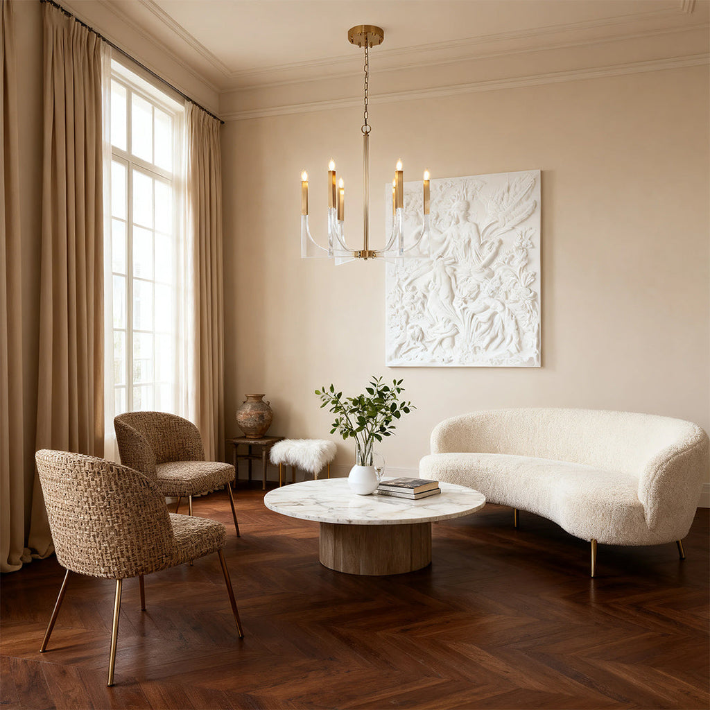 Modern transitional acrylic chandeliers with a brass frame and clear block accents, illuminating a stylish living room with textured furniture.