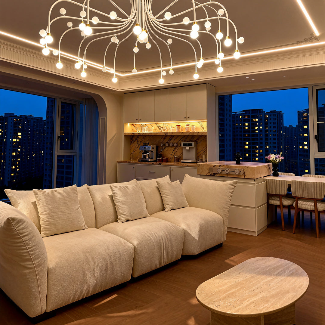 Modern retro chandelier suspended in luxury penthouse living room with beige sectional and evening city views