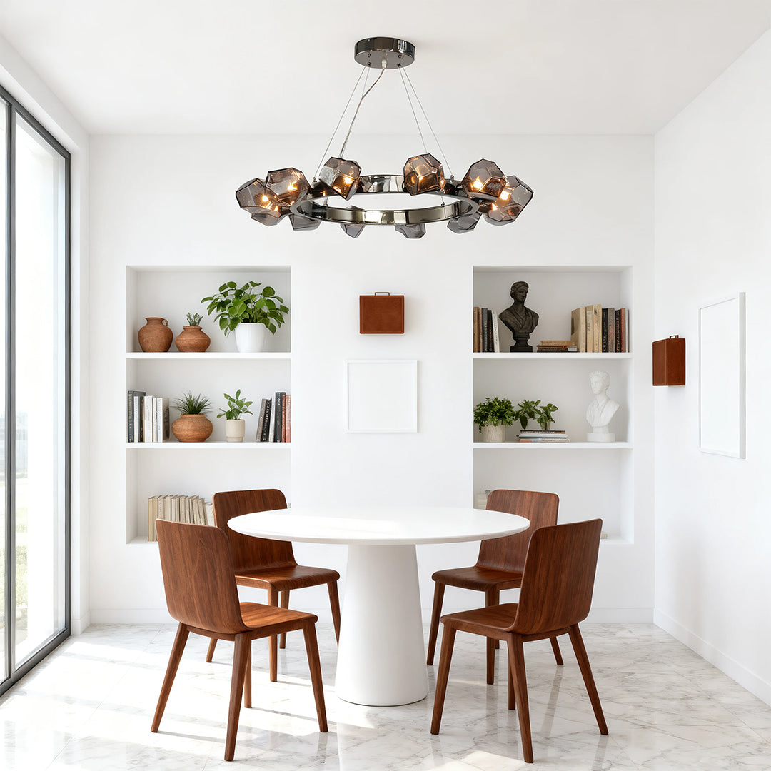 Modern dining area with a statement black round chandelier featuring smokey glass stones hanging above a small white circular table.